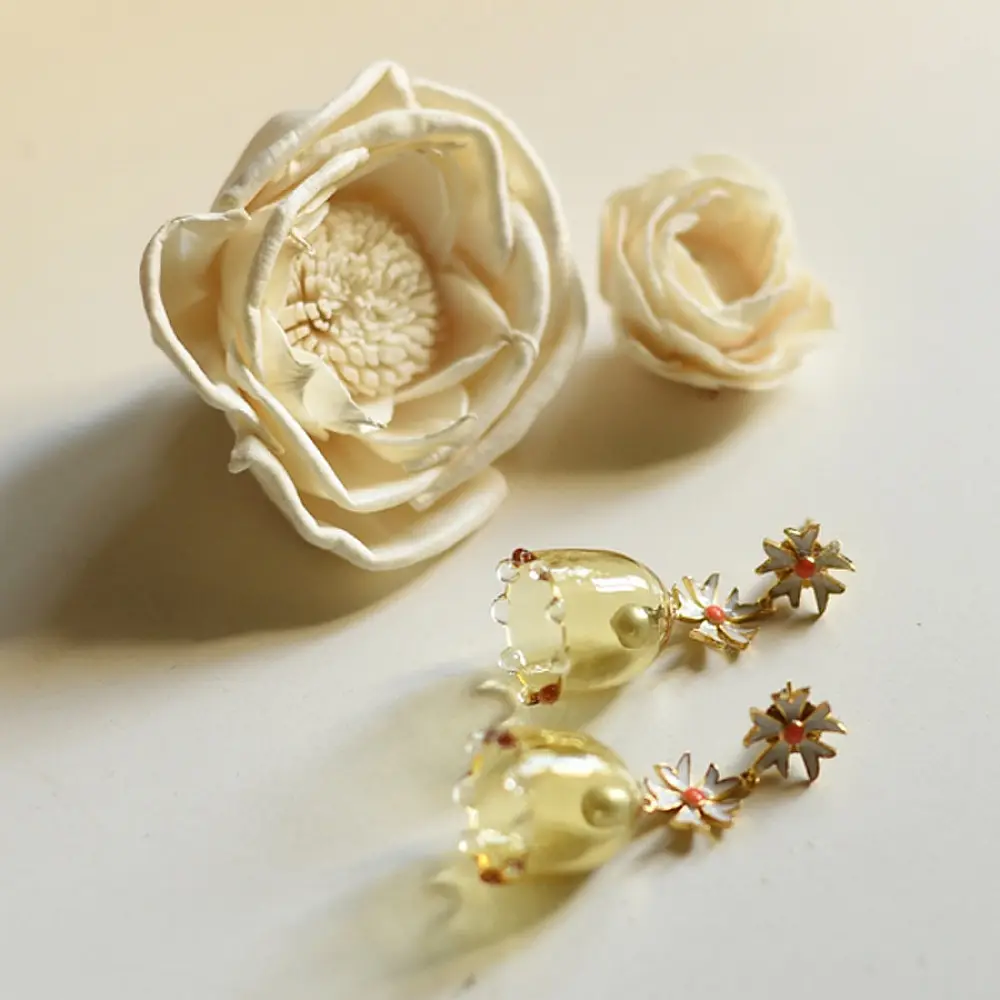 handcrafted pushpa bell jhumka drop earrings featuring a translucent yellow glass bell and white daisy floral stud top   