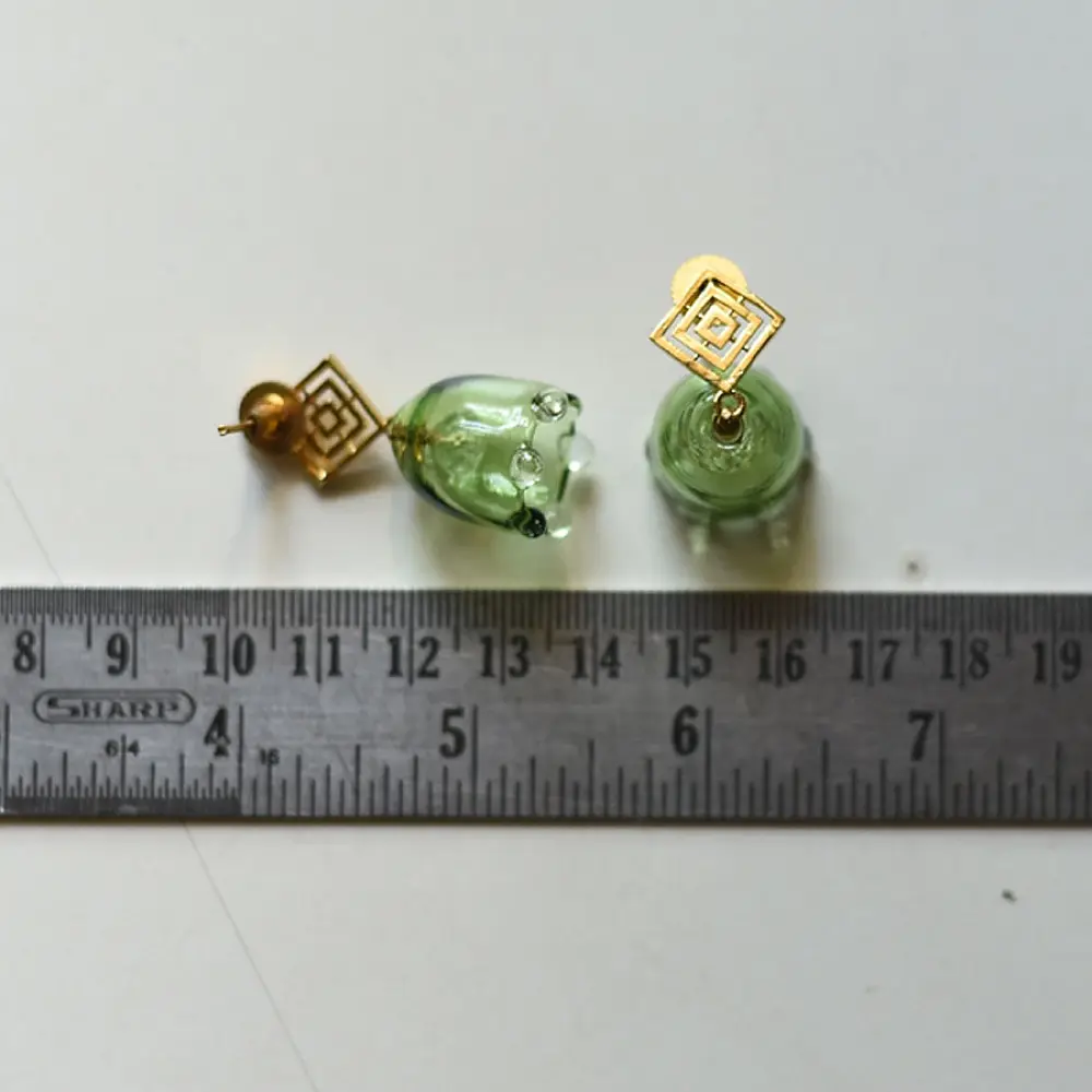 handcrafted sage green glass drop earrings featuring a bell blossom and orb dangle with brass geometric stud tops