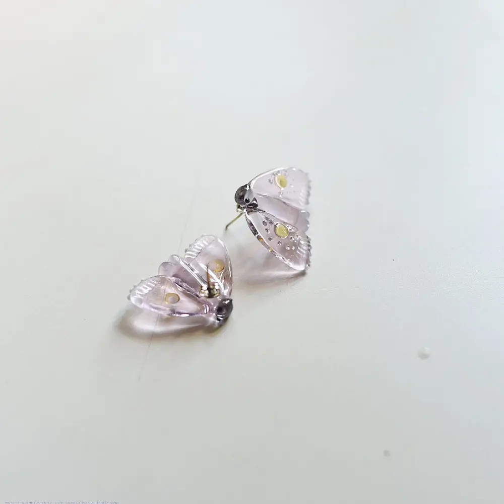 handcrafted translucent pale pink glass moth stud earrings featuring textured grooved wings and yellow spot accents