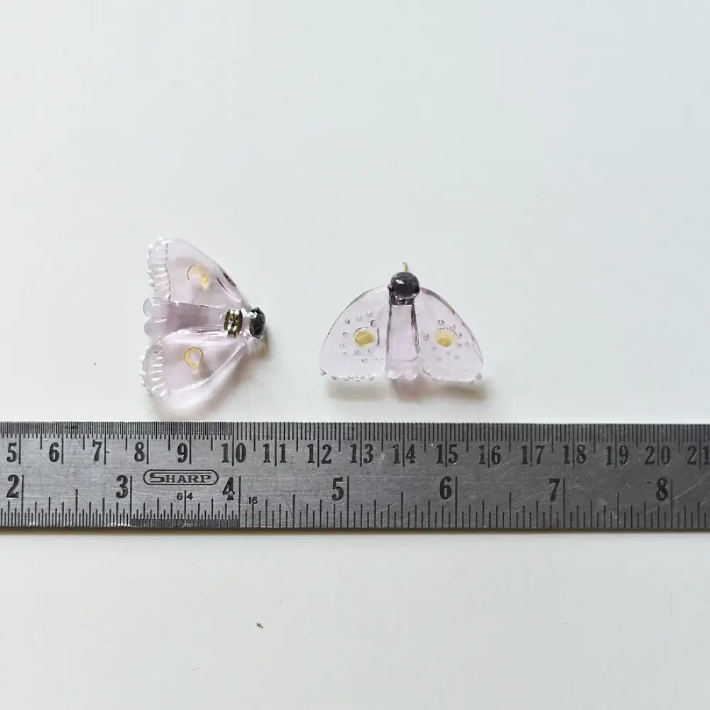 handcrafted translucent pale pink glass moth stud earrings featuring textured grooved wings and yellow spot accents