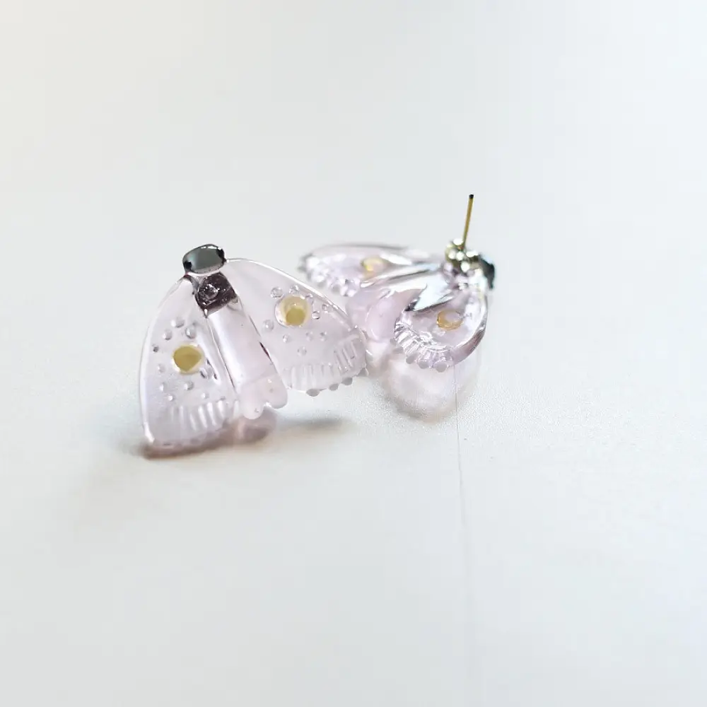 handcrafted translucent pale pink glass moth stud earrings featuring textured grooved wings and yellow spot accents
