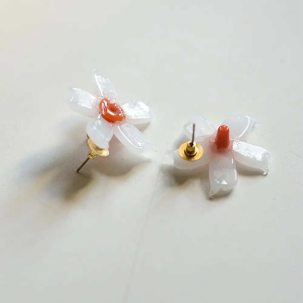 handcrafted shiuli flower glass stud earrings featuring white petaled blooms with vibrant orange center cores   
