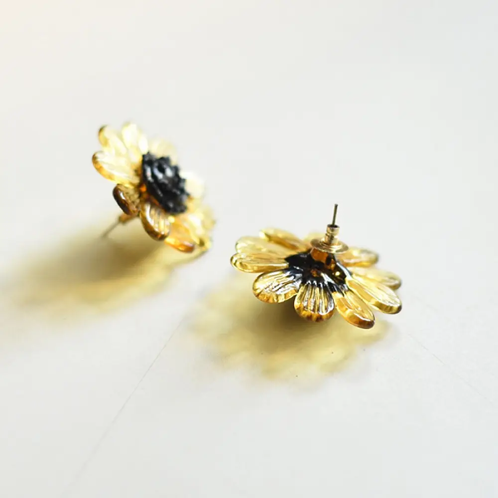 handcrafted translucent amber yellow glass bloom stud earrings with a dark textured center cap on brass post backs