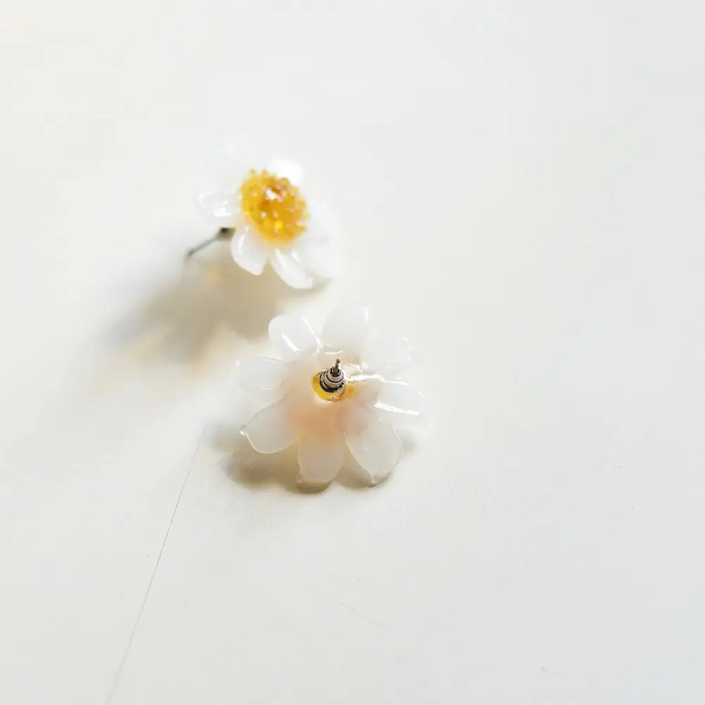 handcrafted translucent frosted glass daisy stud earrings featuring layered white petals and a textured amber yellow center cap