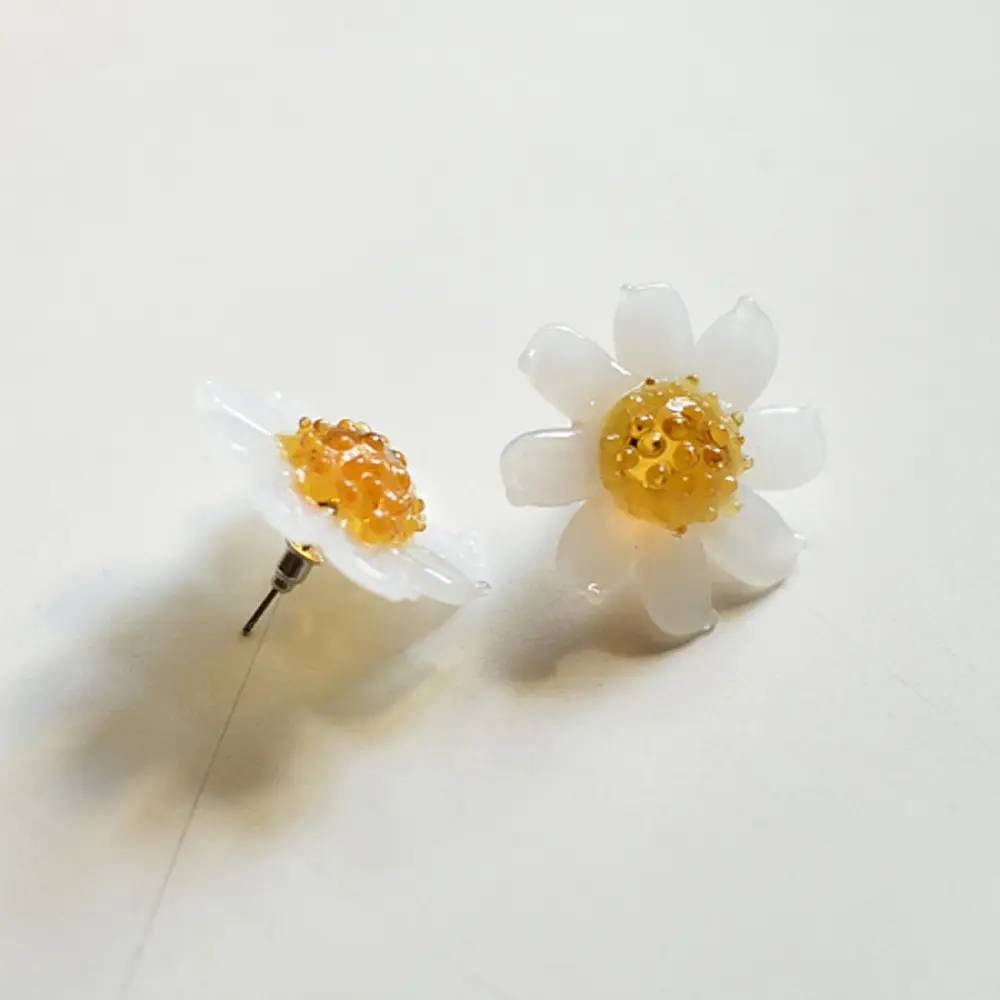 handcrafted translucent frosted glass daisy stud earrings featuring layered white petals and a textured amber yellow center cap