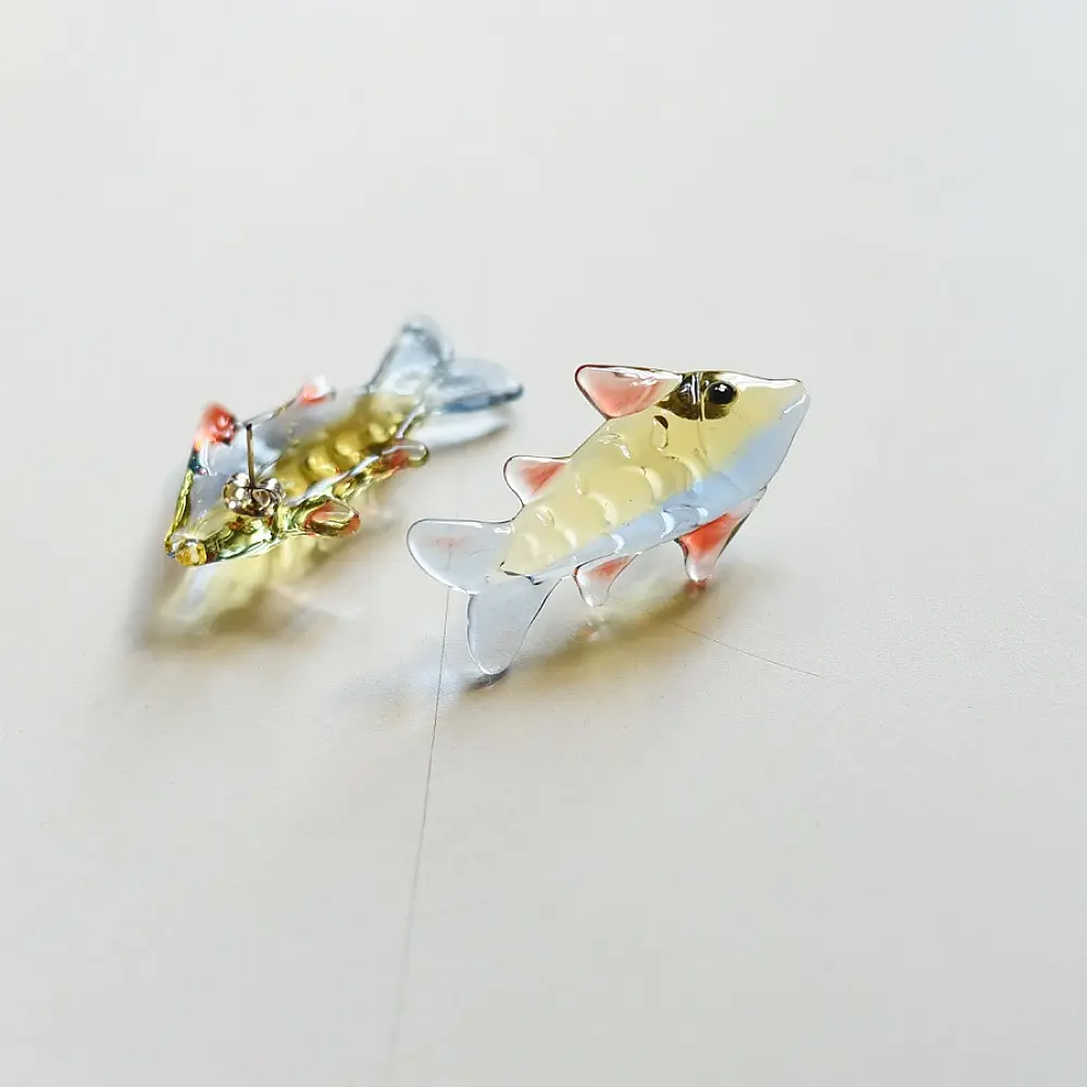 handcrafted glass fish drop earrings featuring yellow and red translucent bodies with delicate light blue fins on hook wires