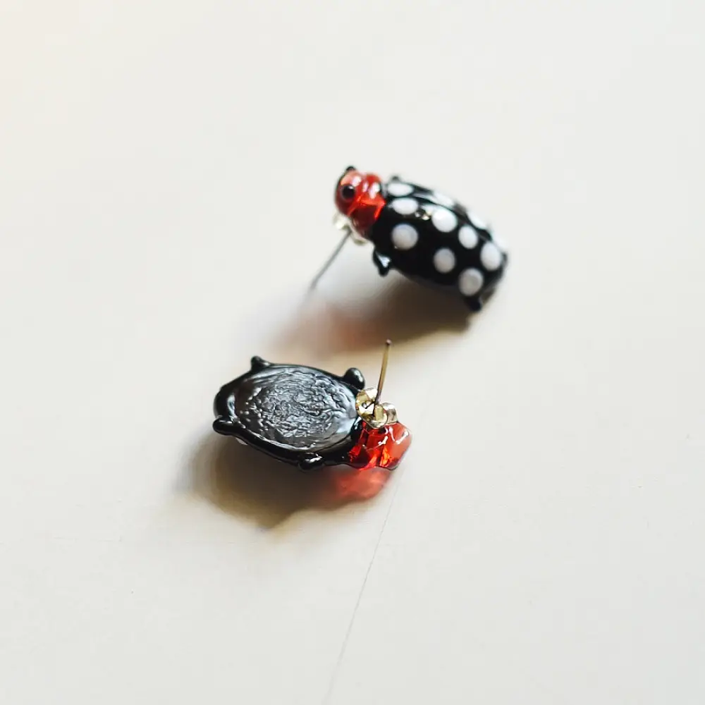 handcrafted black and white polka dot ladybug lampwork glass stud earrings named polka bug with red head accents   