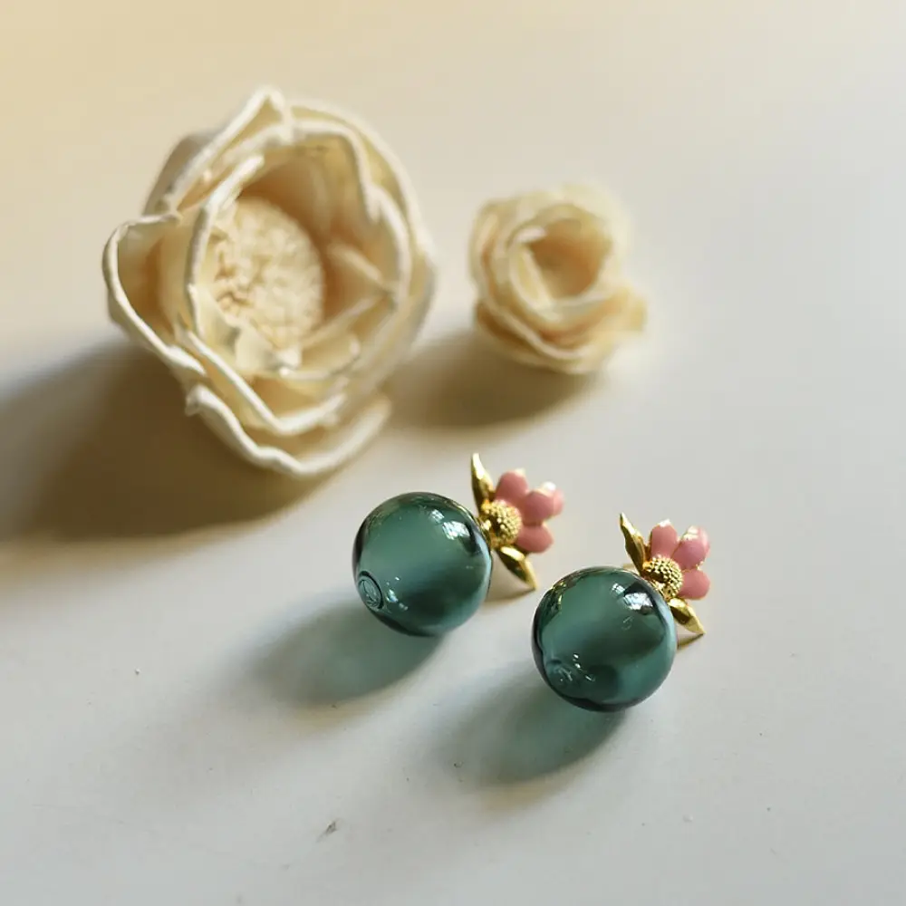 handcrafted deep emerald green glass orb stud earrings crowned with a lotus bud top on brass posts