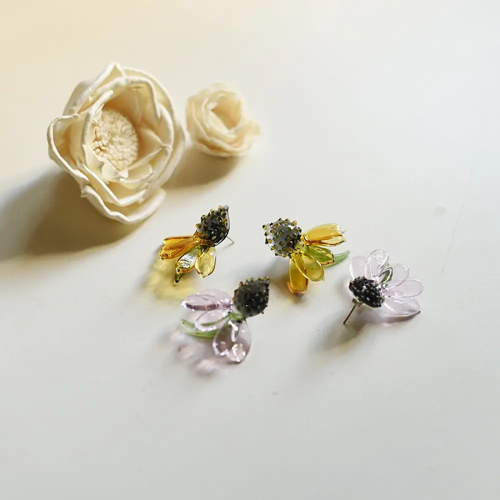 handcrafted translucent amber yellow glass sunflower stud earrings featuring a textured dark beaded center cap