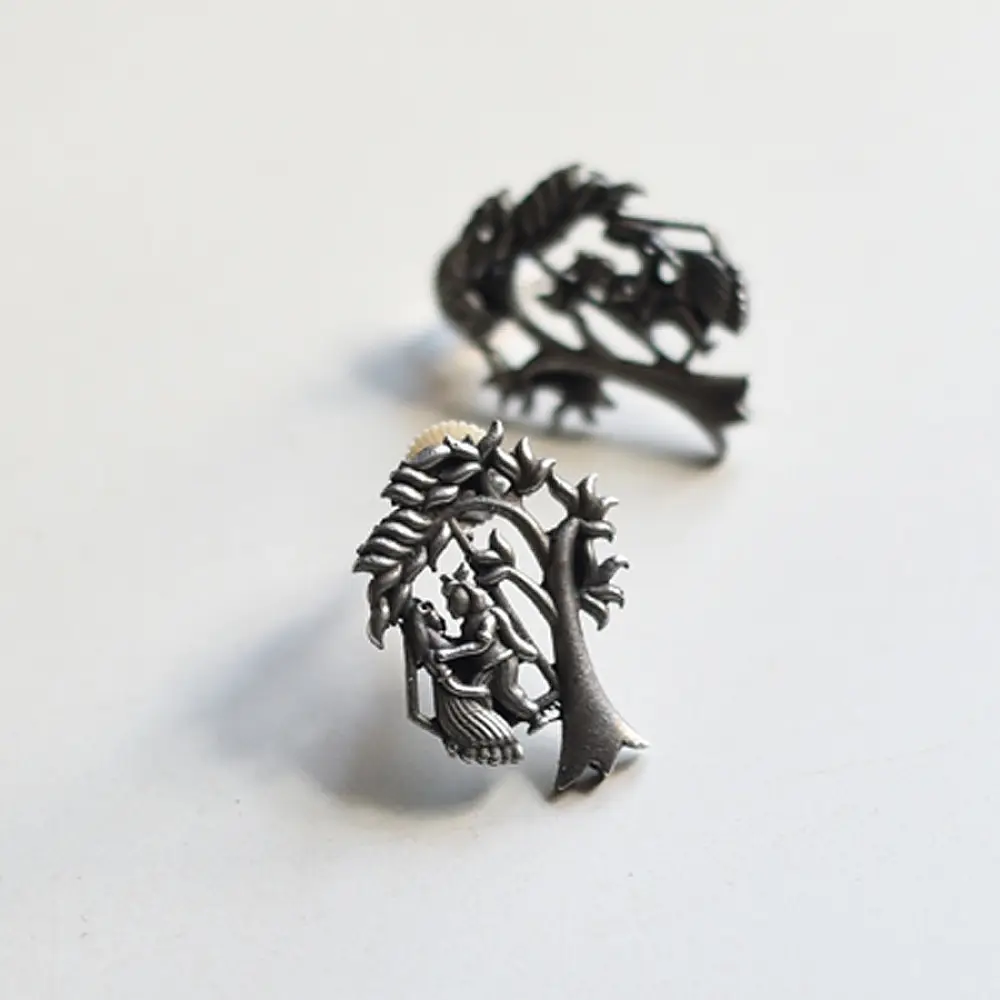 handcrafted german silver radha krishna stud earrings featuring divine figures beneath a branching kadamba tree canopy in oxidised antique finish