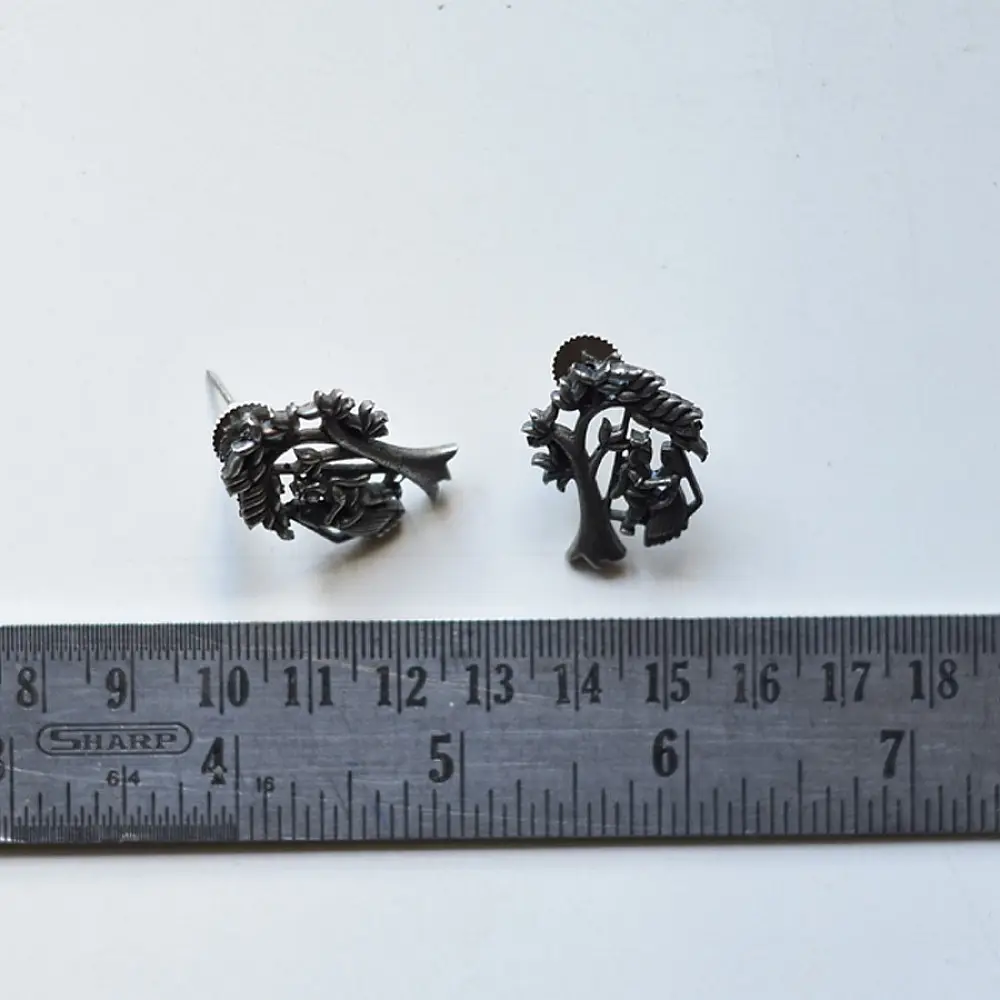 handcrafted german silver radha krishna stud earrings featuring divine figures beneath a branching kadamba tree canopy in oxidised antique finish