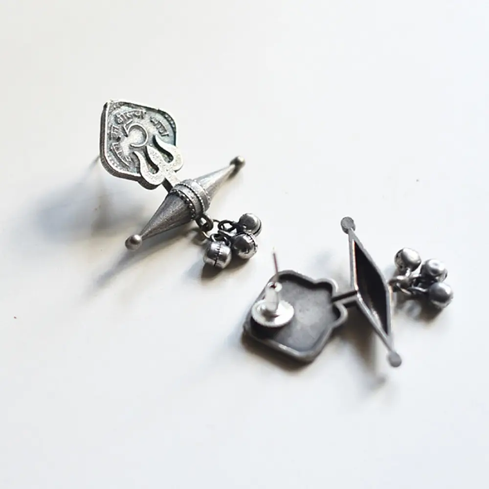 handcrafted german silver trishul stud earrings featuring lord shiva sacred trident motif, central damru drum detail, and oxidised antique finish