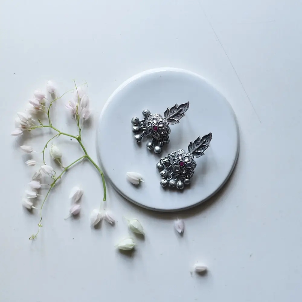 handcrafted german silver floral cluster stud earrings featuring a stone-studded blossom, textured leaf branch, and ruby red inlays