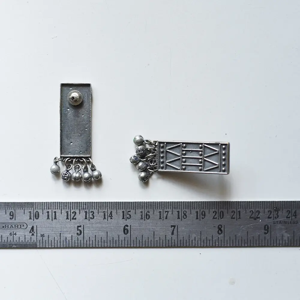 handcrafted german silver geometric rectangular drop earrings featuring woven triangular lattice cutouts, textured stud top, and dangling ghungroo bead cluster