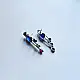 handcrafted german silver bird stud earrings featuring a cobalt blue stone body, jewel-toned glass inlays, and dangling ruby red teardrop tail accent