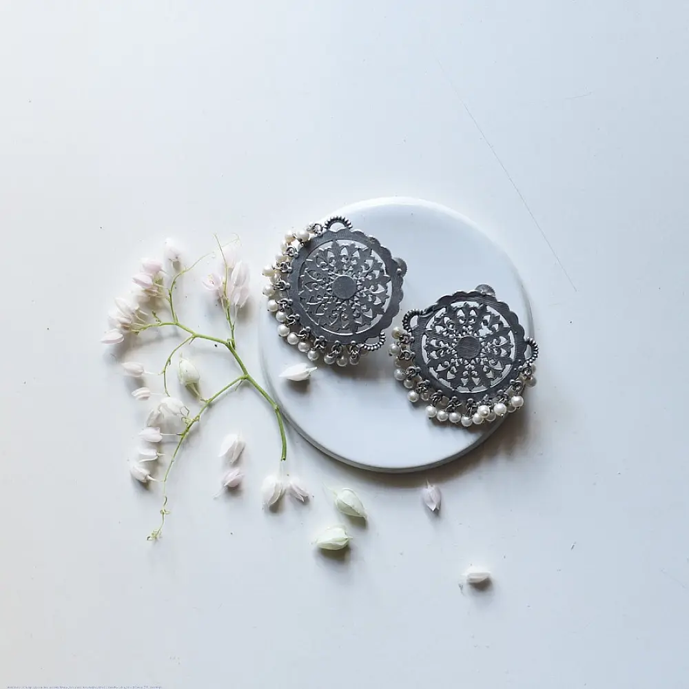 handcrafted german silver circular mandala stud earrings featuring intricate filigree work, scalloped edges, and dangling white pearl ghungroos