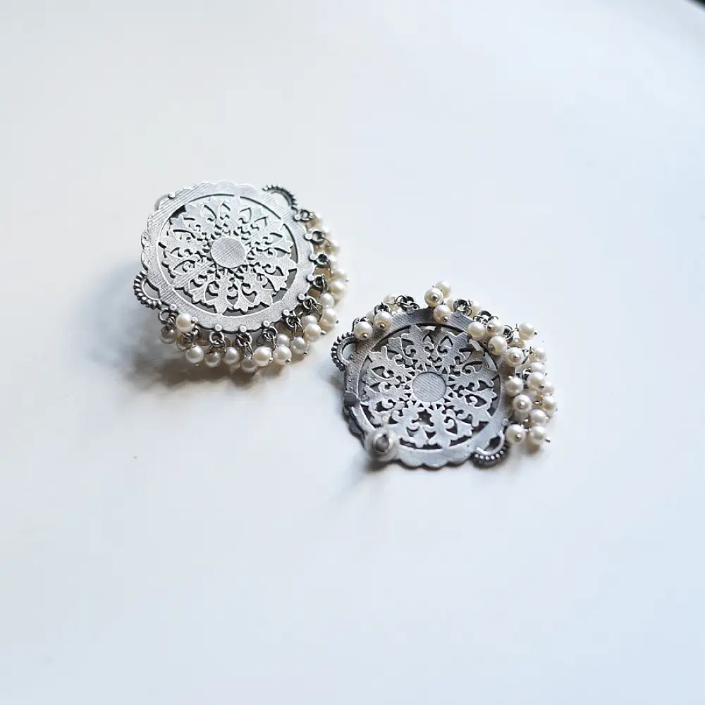 handcrafted german silver circular mandala stud earrings featuring intricate filigree work, scalloped edges, and dangling white pearl ghungroos