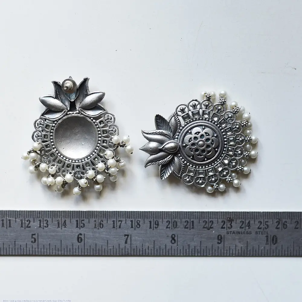 handcrafted german silver lotus motif stud earrings featuring a textured circular centerpiece, radiating petal border, crown leaf crest, and dangling pearl ghungroos