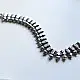 handcrafted german silver choker necklace featuring a central row of textured pyramid spike units, beaded borders, and dangling ghungroo clusters