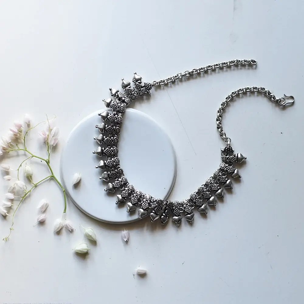 handcrafted german silver choker necklace featuring a central row of textured pyramid spike units, beaded borders, and dangling ghungroo clusters