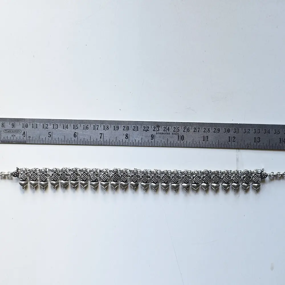 handcrafted german silver choker necklace featuring a central row of textured pyramid spike units, beaded borders, and dangling ghungroo clusters