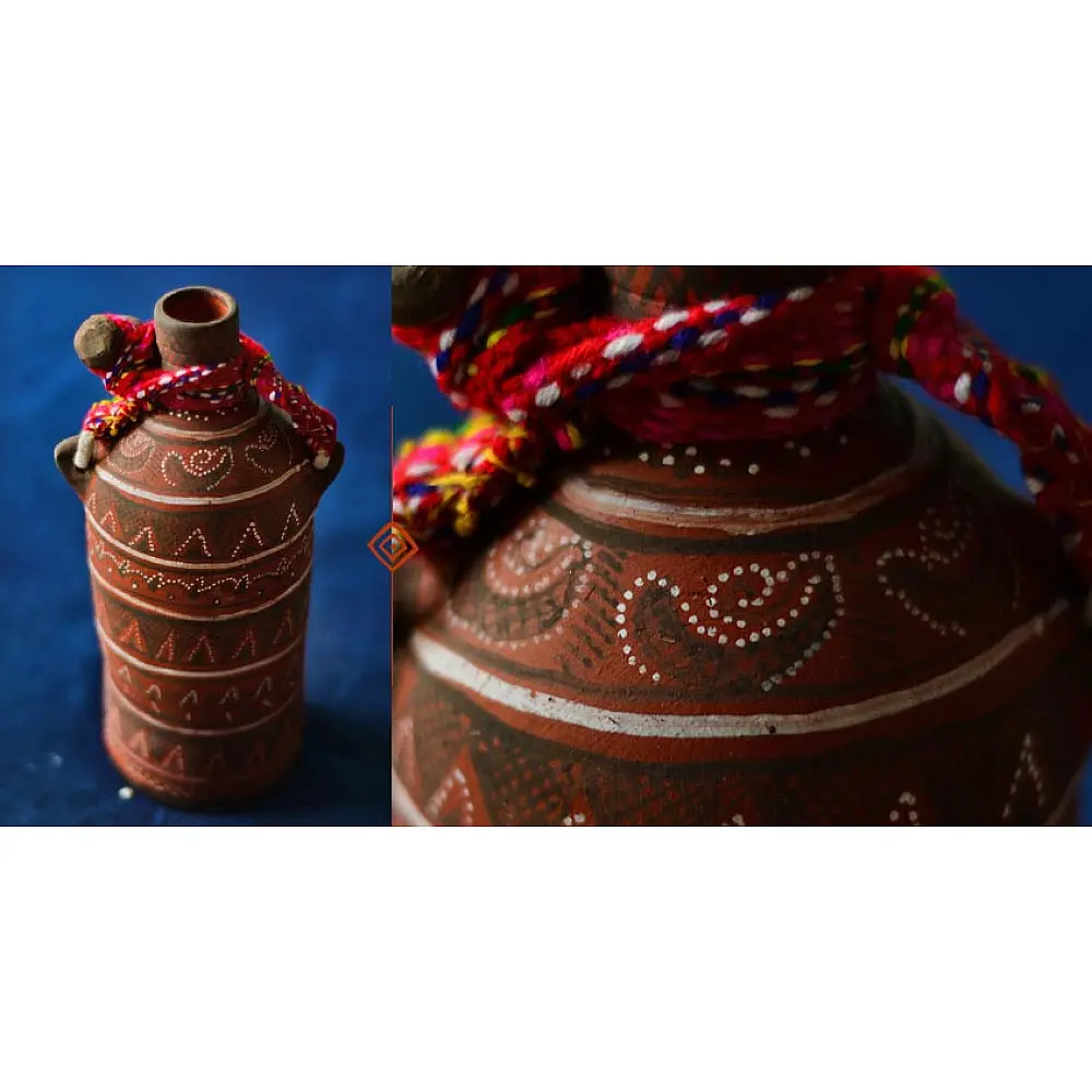 terracotta water bottle with white hand-painted geometric motifs and multicolour cord wrapped neck