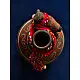 terracotta water bottle with white hand-painted geometric motifs and multicolour cord wrapped neck