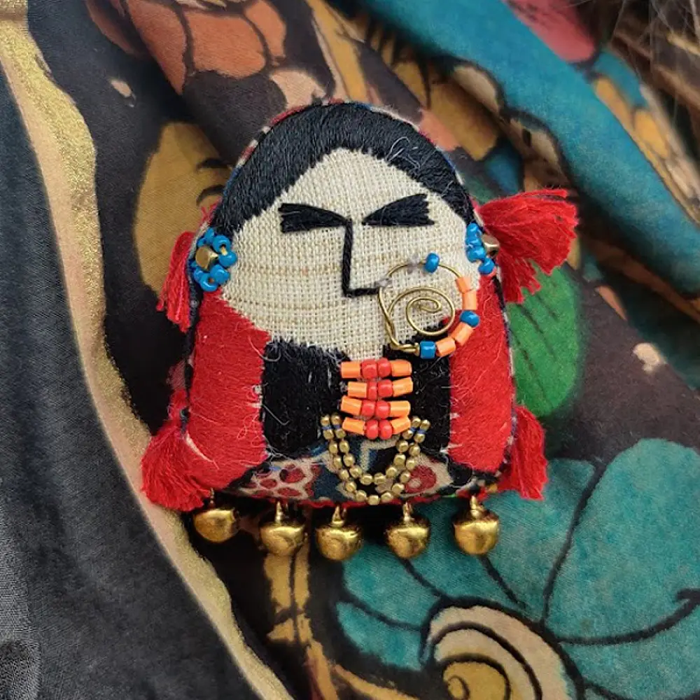woman of kutchh hand embroidered fabric brooch pin with traditional large gold nose ring tribal jewelry thread tassels lapel badge gaatha