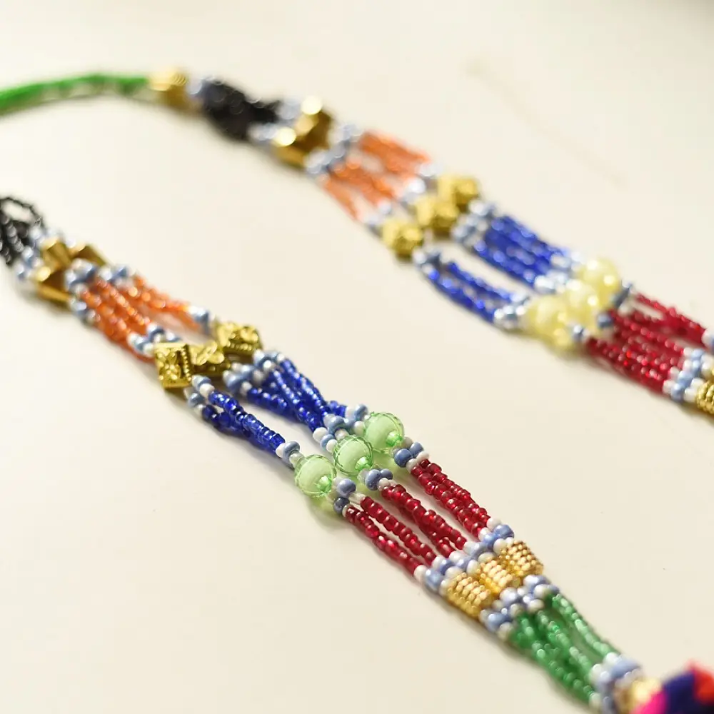 handcrafted banjara triangular embroidered fabric pendant necklace with mirror work pom poms and bright green dori cord