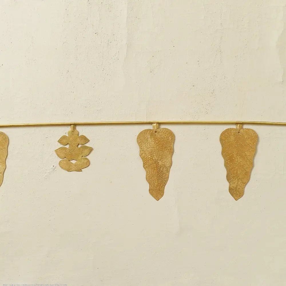 handmade brass leaf design toran door hanging featuring mango leaf shaped brass plates linked on a brass chain with central floral pendant
