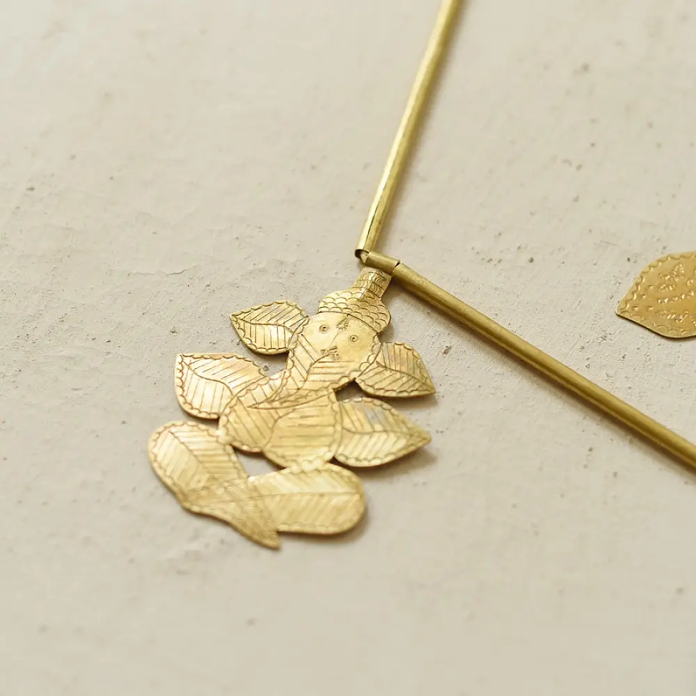 handmade brass leaf design toran door hanging featuring mango leaf shaped brass plates linked on a brass chain with central floral pendant
