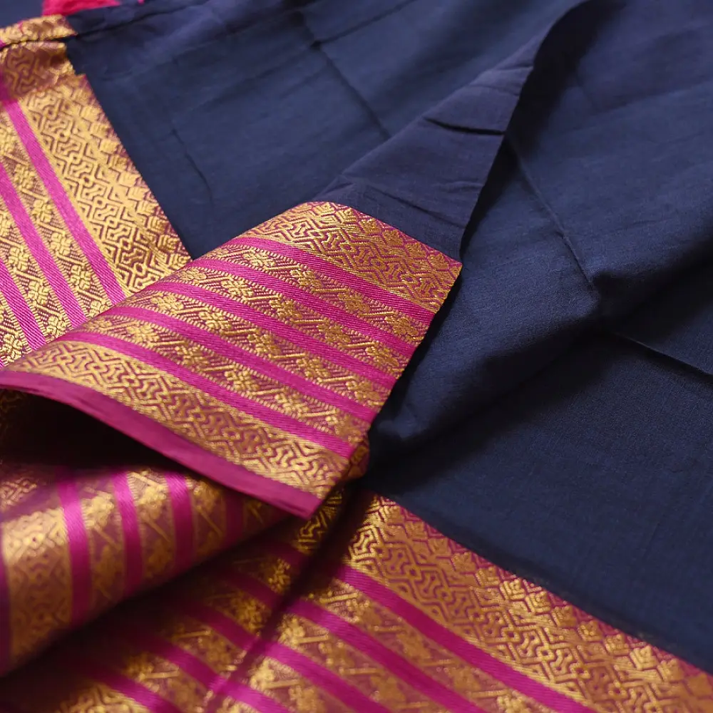 handloom pure cotton saree in deep ink blue with contrasting magenta pink striped zari border and handcrafted tassels on pallu 