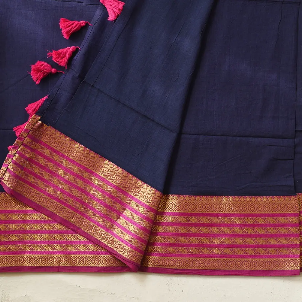 handloom pure cotton saree in deep ink blue with contrasting magenta pink striped zari border and handcrafted tassels on pallu 