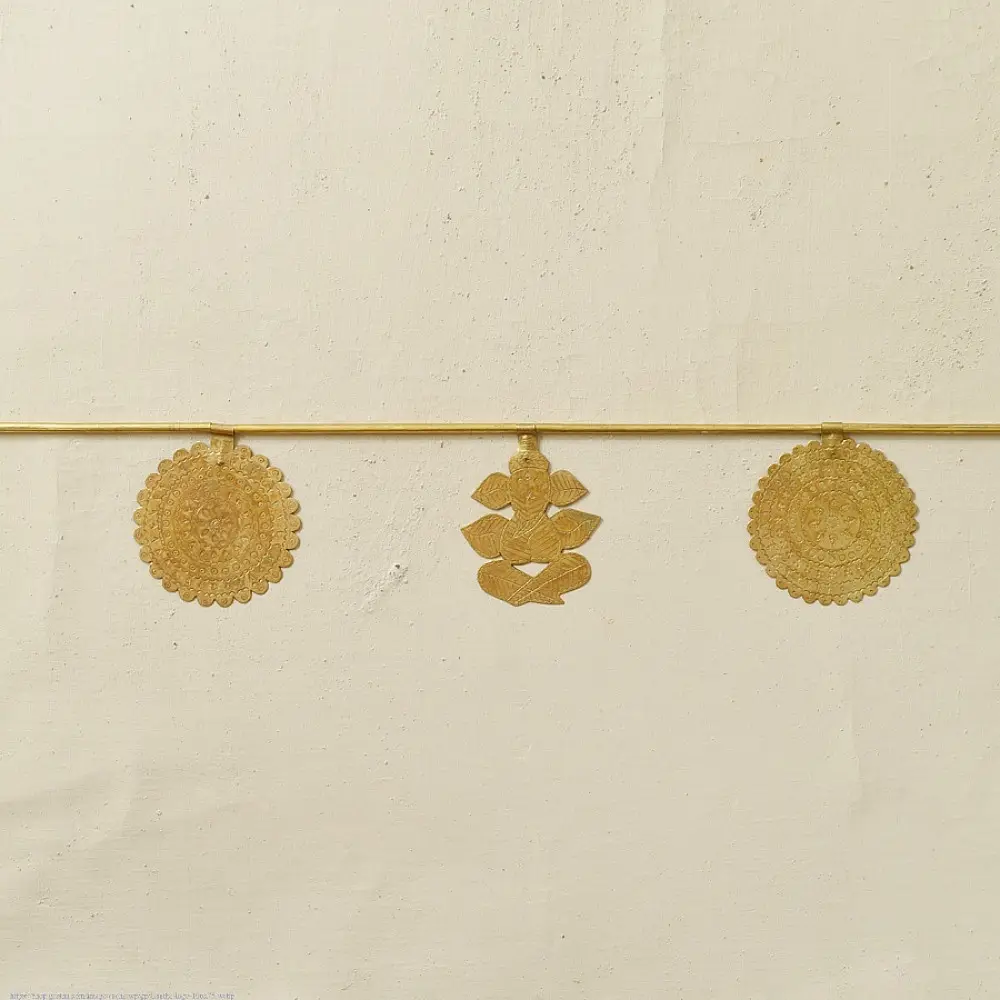 handmade brass toran door hanging featuring scalloped circular brass discs linked on a brass chain with a central floral pendant drop   