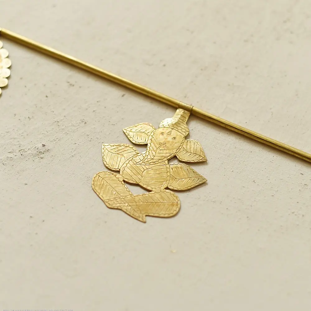handmade brass toran door hanging featuring scalloped circular brass discs linked on a brass chain with a central floral pendant drop   