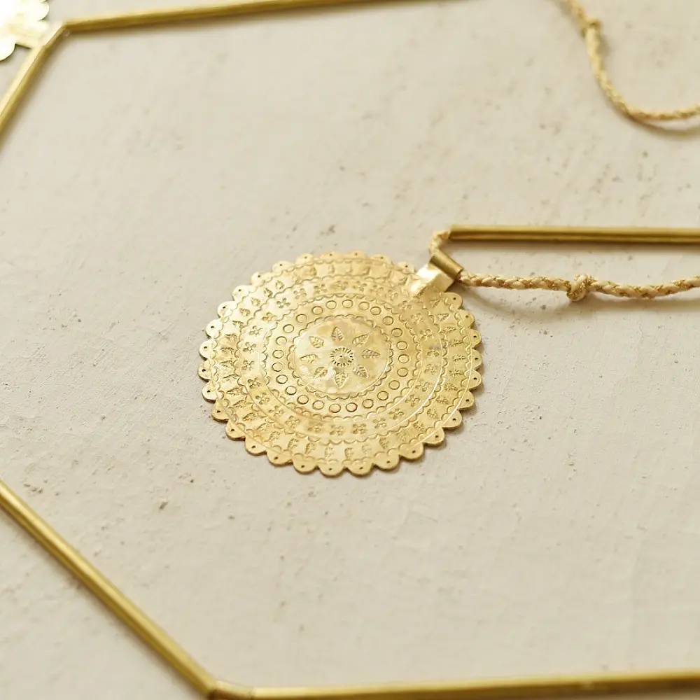 handmade brass toran door hanging featuring scalloped circular brass discs linked on a brass chain with a central floral pendant drop   