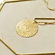handmade brass toran door hanging featuring scalloped circular brass discs linked on a brass chain with a central floral pendant drop   