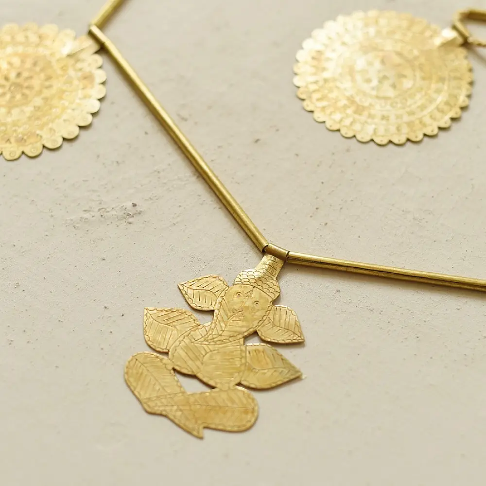 handmade brass toran door hanging featuring scalloped circular brass discs linked on a brass chain with a central floral pendant drop   