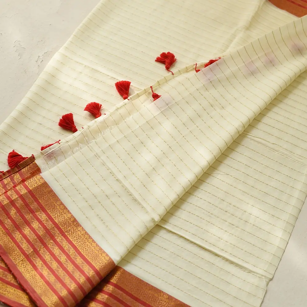 handloom pure cotton saree in soft ivory white featuring a contrasting rust orange striped zari border and handcrafted tassels on pallu