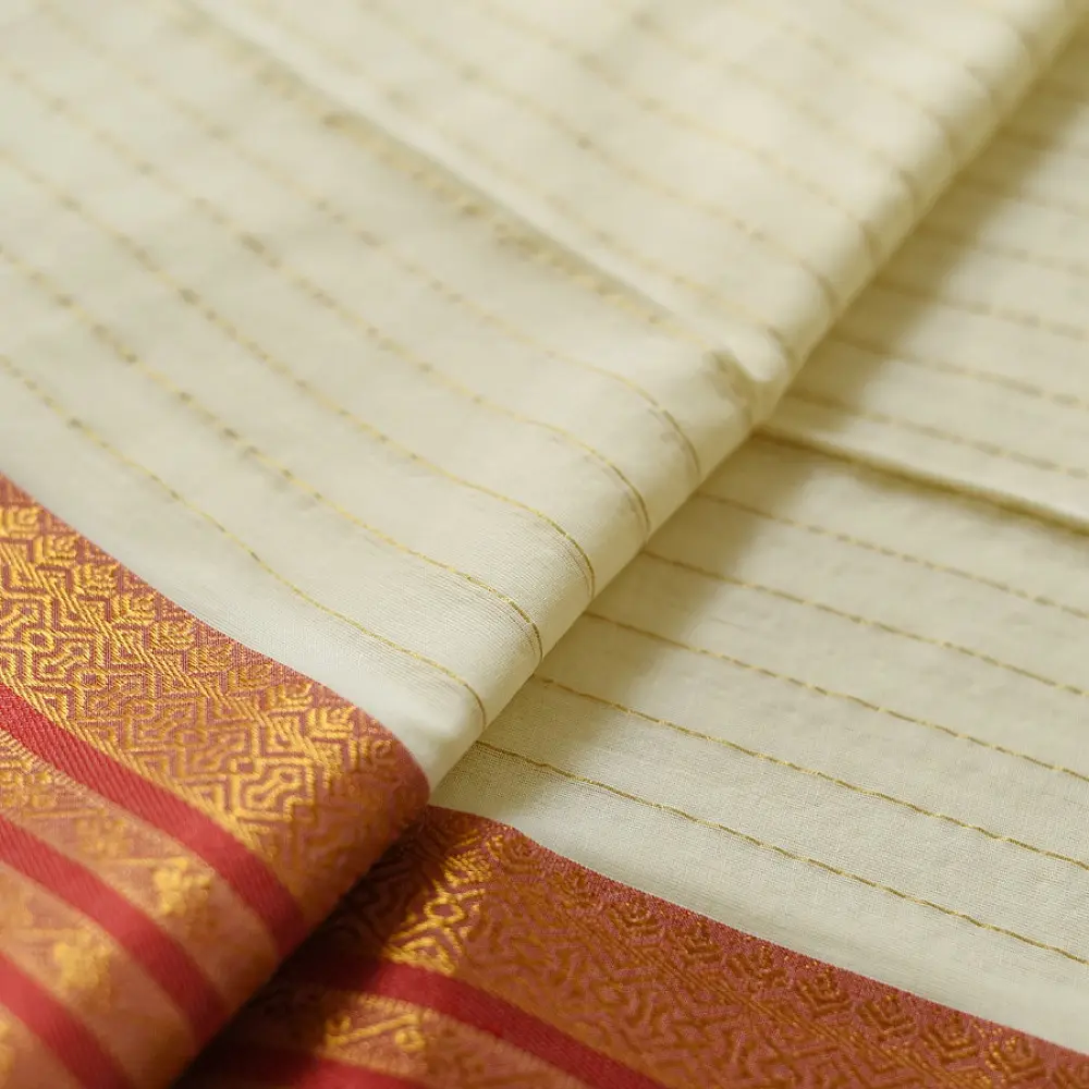 handloom pure cotton saree in soft ivory white featuring a contrasting rust orange striped zari border and handcrafted tassels on pallu