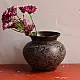 handmade antique dark brass lota with engraved peacock and geometric motifs used as a decorative vessel