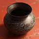 handmade antique dark brass lota with engraved peacock and geometric motifs used as a decorative vessel