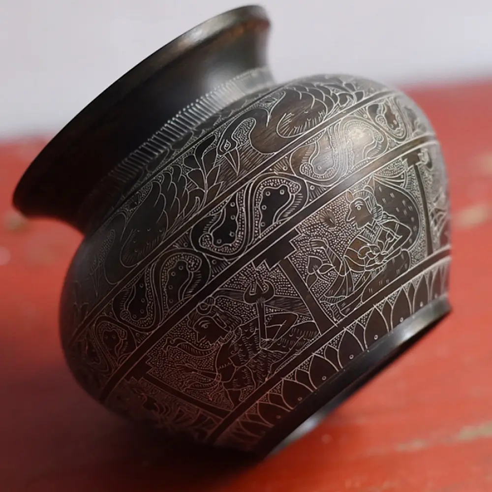 handmade antique dark brass lota with engraved peacock and geometric motifs used as a decorative vessel