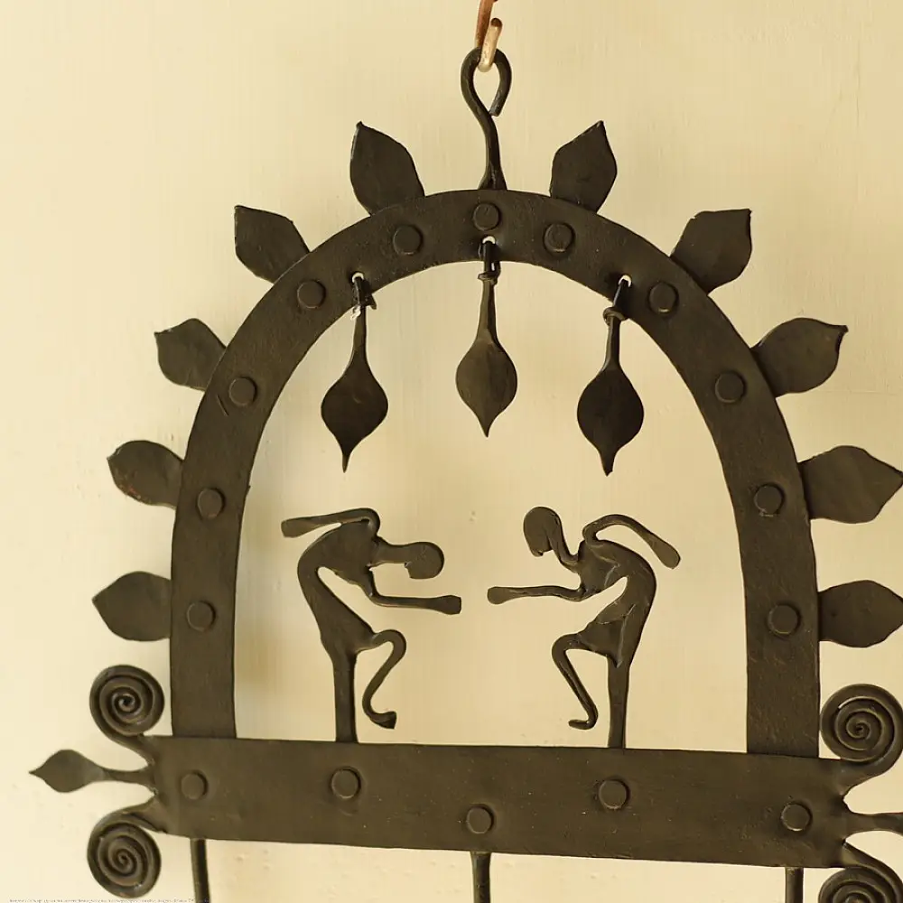 handcrafted black wrought iron arched wall hanger featuring two stylized tribal human figures, top hanging dome drops, and lower storage hooks