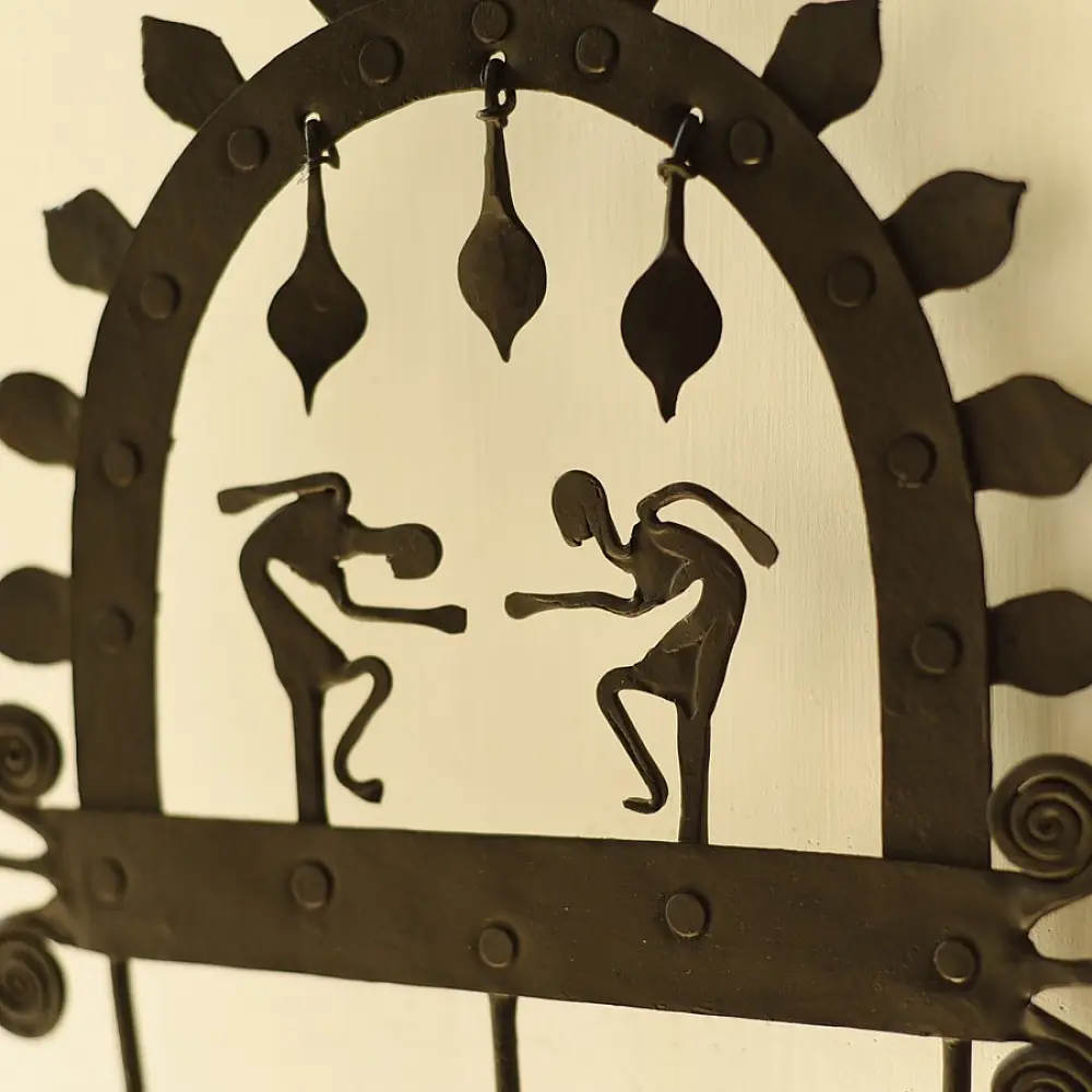 handcrafted black wrought iron arched wall hanger featuring two stylized tribal human figures, top hanging dome drops, and lower storage hooks
