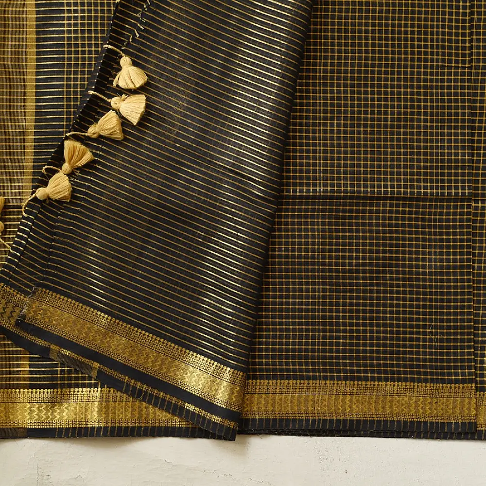 handloom pure cotton saree in classic black featuring fine golden zari checked pattern throughout the body with a rich gold zari border and handcrafted tassels