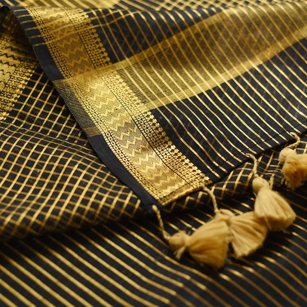 handloom pure cotton saree in classic black featuring fine golden zari checked pattern throughout the body with a rich gold zari border and handcrafted tassels