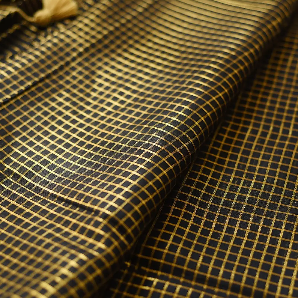 handloom pure cotton saree in classic black featuring fine golden zari checked pattern throughout the body with a rich gold zari border and handcrafted tassels