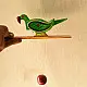 handcrafted wooden moving parrot toy painted in traditional green and red with a dangling weight mechanism