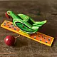 handcrafted wooden moving parrot toy painted in traditional green and red with a dangling weight mechanism